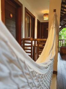 a white hammock hanging in a room at Pousada João Sol in Praia do Forte