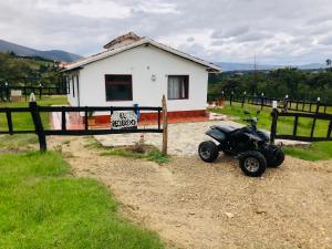 a motor scooter parked in front of a house at el recuerdo in Villa de Leyva