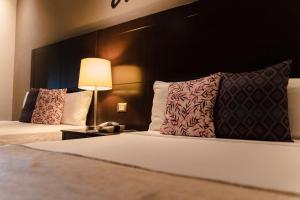 um quarto de hotel com duas camas e um candeeiro em Punto Madero Hotel & Plaza em Mocorito