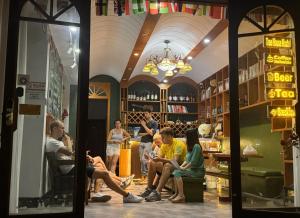 un groupe de personnes assises dans un bar dans l'établissement Edinburgh Hostel, à Zhangjiajie