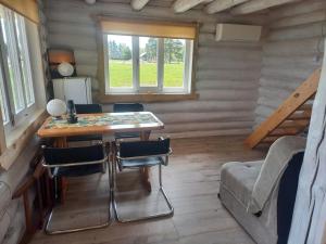 a room with a table and chairs in a log cabin at Lakefront Lodge in Mustvee