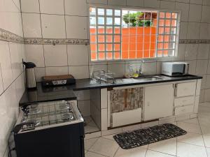 a small kitchen with a stove and a sink at Casa Grande Centro in Rio Verde