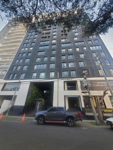a truck parked in front of a tall building at Apartamento Frente a Parque en Urb. California in Víctor Larco Herrera