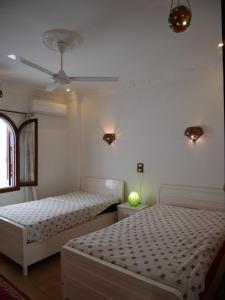 a bedroom with two beds and a ceiling fan at Villa Quiet Place in Luxor
