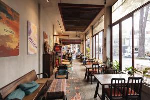 a restaurant with tables and chairs and windows at 9 Hostel and Bar in Ho Chi Minh City