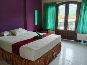 a bedroom with a bed with a dinosaur on it at Grand Palem Hotel in Songgoriti