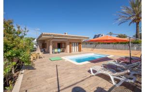 un patio trasero con piscina y una casa en Beautiful Home In Port Adriano With Kitchen en El Toro