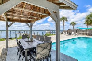 uma área de refeições com uma mesa e cadeiras ao lado de uma piscina em Aqua Paradisaea em Saint Augustine