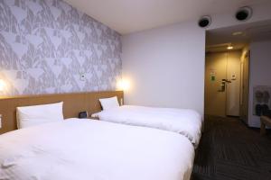 Postel nebo postele na pokoji v ubytování Dormy Inn Chiba City Soga