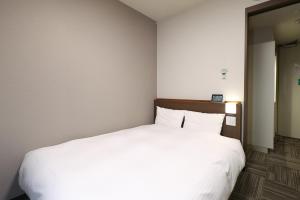 Postel nebo postele na pokoji v ubytování Dormy Inn Chiba City Soga