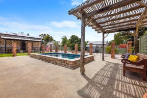 a swimming pool in a patio with a wooden pergola at Arapiles Club House in Natimuk