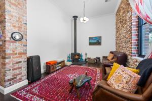 a living room with a couch and a brick wall at Arapiles Club House in Natimuk
