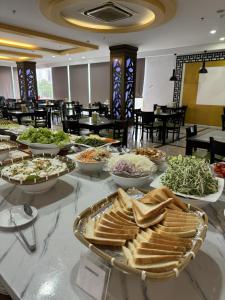 bufet z jedzeniem na stole w restauracji w obiekcie Happy Light Hotel Nha Trang w mieście Nha Trang