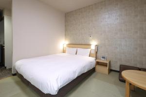 Postel nebo postele na pokoji v ubytování Dormy Inn Chiba City Soga