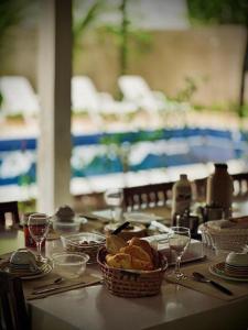 a table with a basket of bread and wine glasses at Casa San Francisco in Porto Seguro
