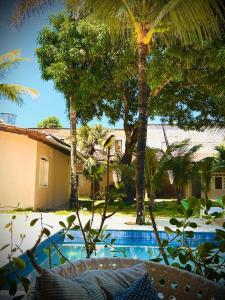 a resort with a swimming pool and palm trees at Casa San Francisco in Porto Seguro