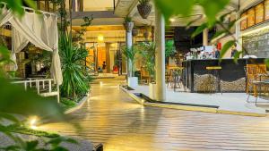 un centro commerciale vuoto con piante e un bar dentro di The Luxury a Siem Reap