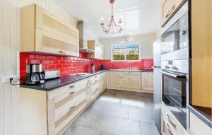 eine Küche mit weißen Schränken und roten Ziegelwänden in der Unterkunft 3 Bedroom Lovely Home In Saint-Malo in Saint-Malo