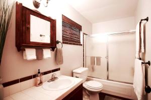 a bathroom with a toilet and a sink and a shower at Glimmer Chalet Treetop A-frame cabin lake view in Lake Arrowhead +34 photos