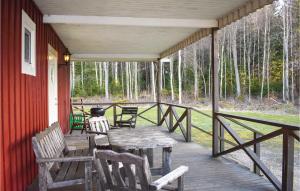 a porch with a wooden table and chairs on it at 3 Bedroom Amazing Home In Holmsjö in Holmsjö