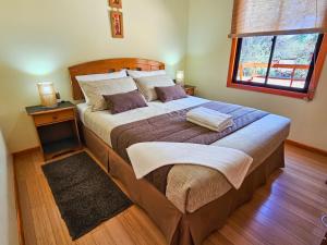 a bedroom with a large bed with a table and a window at Lodge Ancar Atacama in San Pedro de Atacama