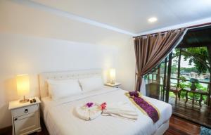 a bedroom with a bed and a balcony at Nangyuan Island Dive Resort in Ko Tao