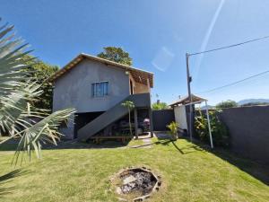 a small house in a yard with a grassy backyard at Suite independente com garagem prox à praia da Vila in Saquarema