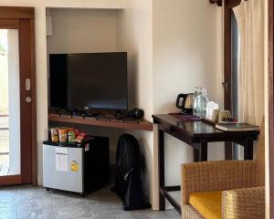 uma sala de estar com uma televisão e uma mesa com um televisionizador em Chumphon Cabana Resort em Chumphon