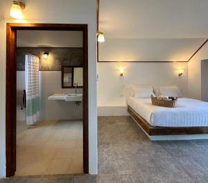 1 dormitorio con 1 cama y baño con lavamanos en Chumphon Cabana Resort en Chumphon
