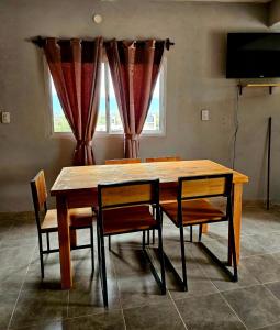a dining room table with chairs and a television at El gumer in San Fernando del Valle de Catamarca