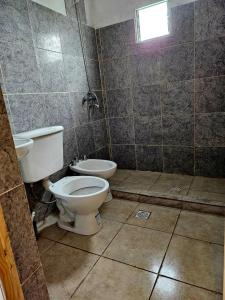 a bathroom with a toilet and a sink at El gumer in San Fernando del Valle de Catamarca