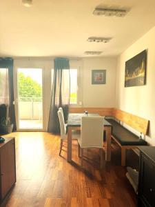 a dining room with a table and white chairs at University Messe Apartment in Graz