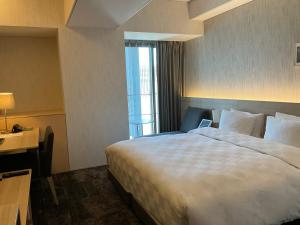 a hotel room with a large bed and a window at Hotel Royal Classic Osaka in Osaka