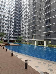 ein großer Pool vor hohen Gebäuden in der Unterkunft Shore 3 Residences Authentic Japanese-Style Bedroom with Pool View - MOA Complex in Manila + 6 Fotos