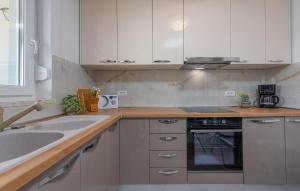 a kitchen with white cabinets and a sink and a stove at 3 Bedroom Lovely Apartment In Mandre in Mandre