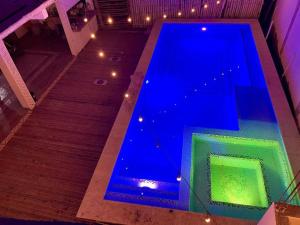 une piscine bleue avec des escaliers et des lumières dans l'établissement MAYAN SURF HOTEL, à El Paredón Buena Vista