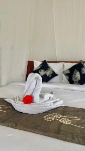 a white towel on a bed with a red stuffed animal at Papahan Bali in Sidemen