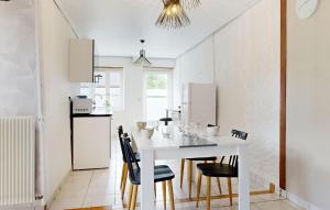 une cuisine et une salle à manger avec une table et des chaises blanches dans l'établissement Cozy Home In Sartilly-Baie-Bocage, à Angey