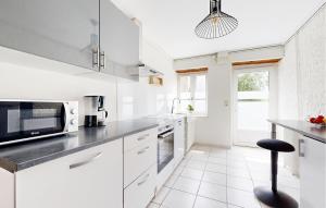 une cuisine avec des armoires blanches et un comptoir noir dans l'établissement Cozy Home In Sartilly-Baie-Bocage, à Angey