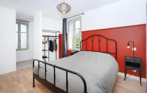 a bedroom with a bed with a red wall at Stunning Home In Le Minihic-Sur-Rance in Le Minihic-sur-Rance