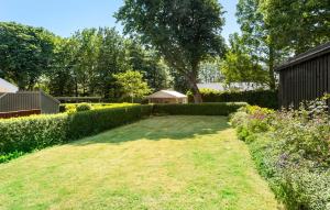 a garden with a large lawn and some bushes at 2 Bedroom Awesome Home In Rudkøbing in Rudkøbing +13 photos