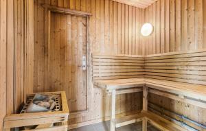 a wooden sauna with a bench and a table at 3 Bedroom Amazing Home In Farsø in Hvalpsund +10 photos