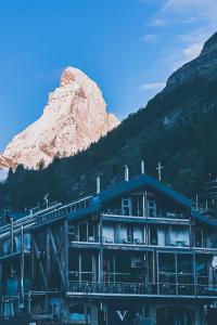 a building with a mountain in the background at Backstage Boutique SPA Hotel in Zermatt
