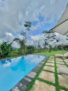 a swimming pool in a villa with a garden at Papahan Bali in Sidemen