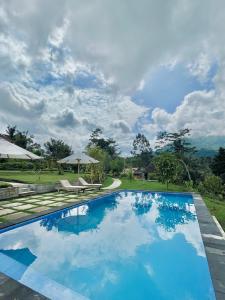 una piscina de agua azul en un complejo en Papahan Bali, en Sidemen