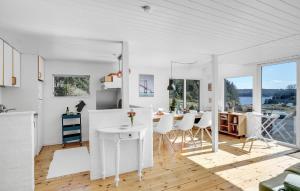 biała kuchnia i jadalnia ze stołem i krzesłami w obiekcie Awesome Home In Hobro With Kitchen w mieście Hobro
