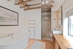 La salle de bains est pourvue d'une grande baignoire et d'un lavabo. dans l'établissement Minstrel Court Wedding Venue, à Cambridge