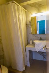 a bathroom with a sink and a shower curtain at agnadi hotel in Achladies