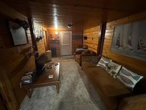 a living room with two couches and a tv at The Beach Cave in Santa Rosa Beach