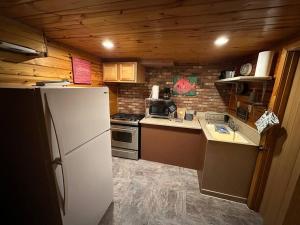 a kitchen with a white refrigerator and a brick wall at The Beach Cave in Santa Rosa Beach